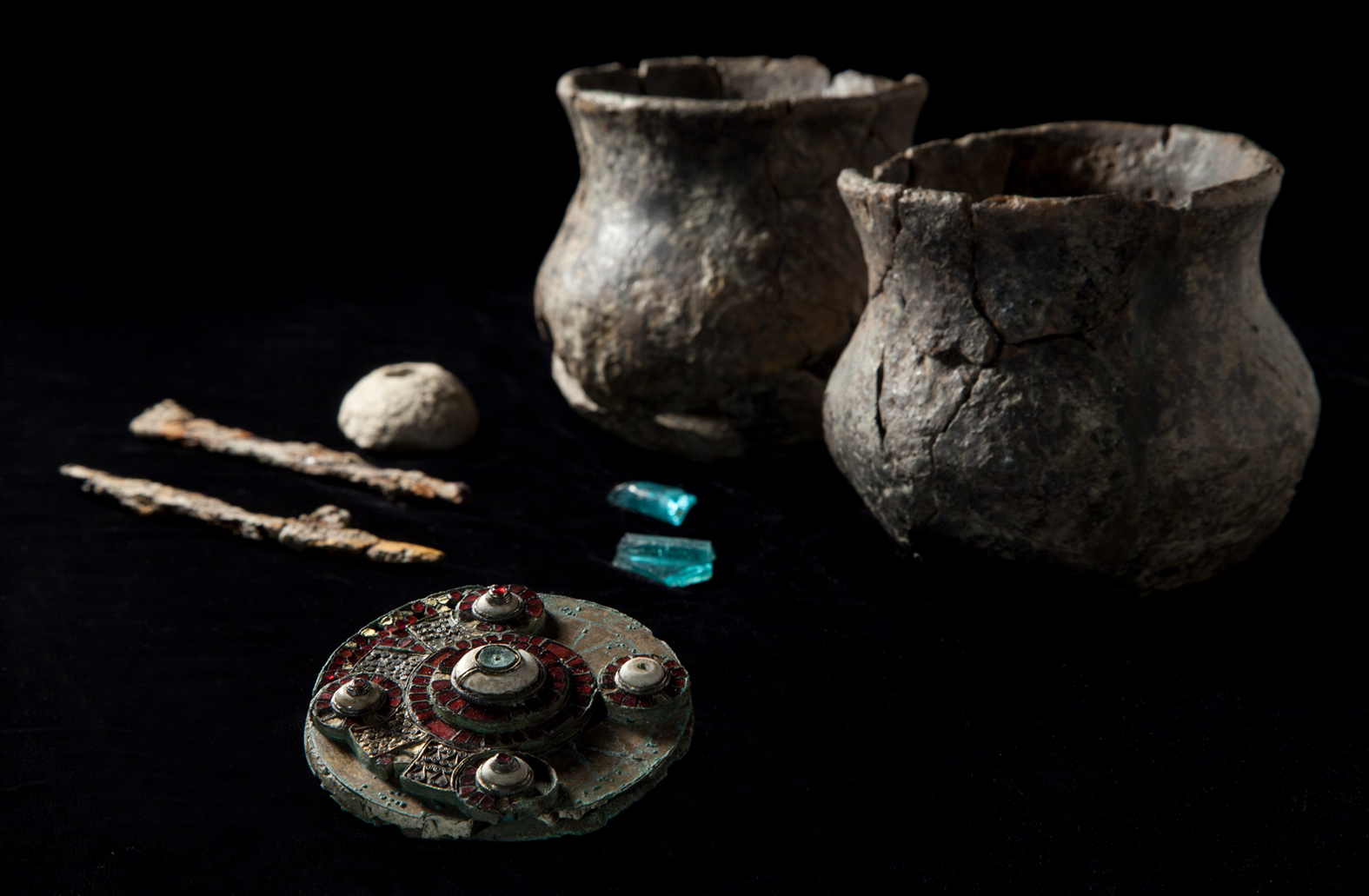 West hanney group robyn A photo of the burial assemblage discovered at West Hanney, including two fragments of glass (apparently from the same vessel), a chalk and spindle whorl, iron knives,and, two small ceramic vessels (most likely cups).