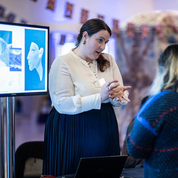 Photo of Dr Victoria Sainsbury demonstrating ancient metal and glass objects to members of the public in the Weston Library, Oxford