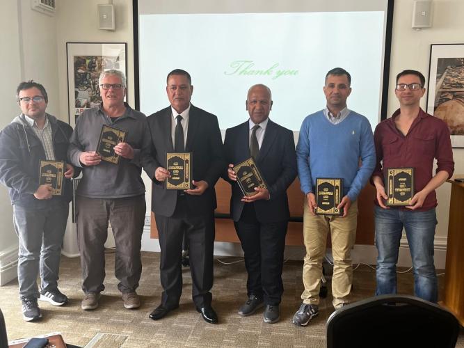 Photo of our honoured seminar speakers alongside members of the EAMENA team. Each person in this photo is holding a volume of the Iraq heritage series