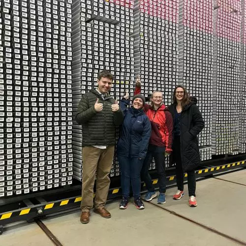 The team stand in front of a wall of ice cores