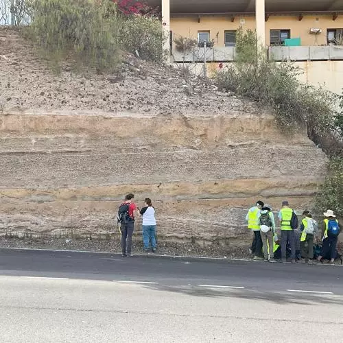 The team assess a stratigraphic cut through a roadside