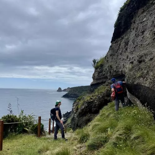 team members surveying geology on a coastal path