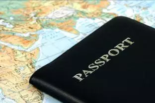 Photo of a generic passport lying flat on top of a map of the world. 